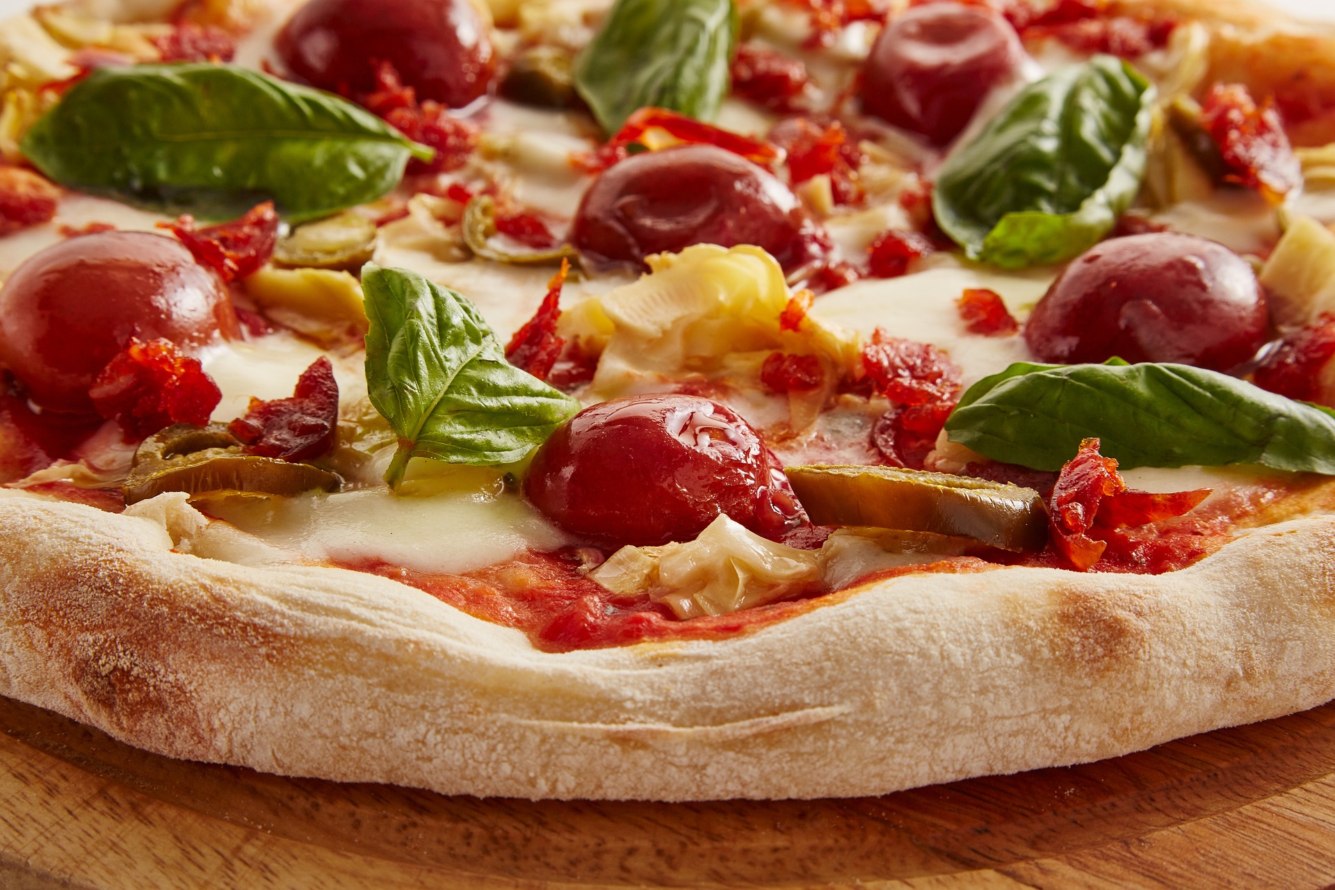 Pizza fatta in casa con olive, basilico e pomodorini